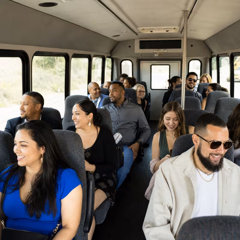 Group boarding a white charter bus for Private Event Transportation transportation in Dallas