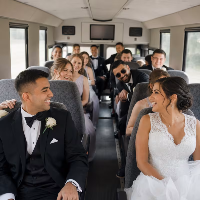 Group boarding a white charter bus for Wedding Transportation transportation in Dallas