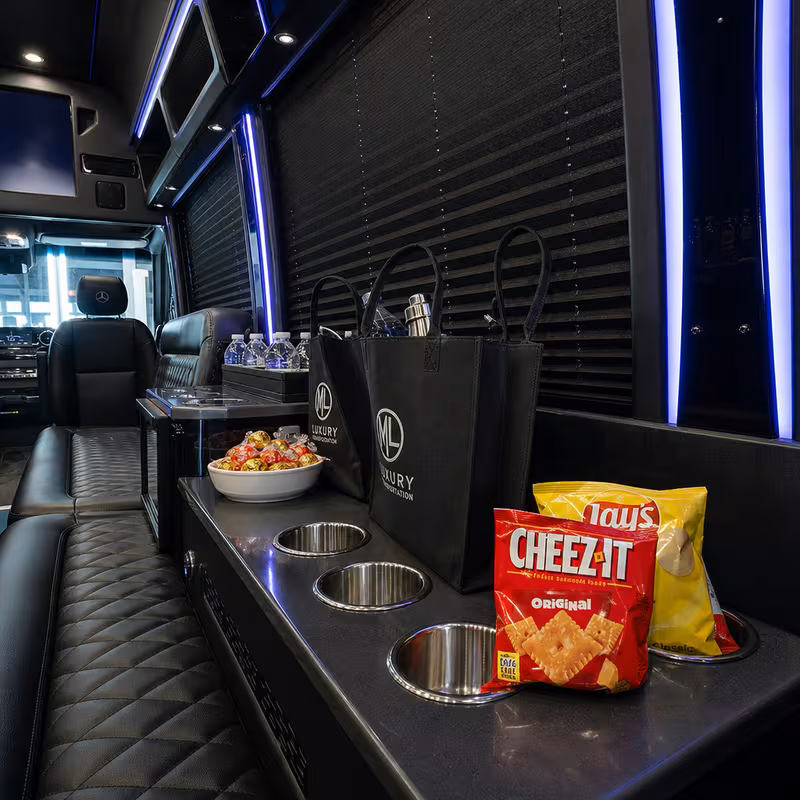 Party bus interior with wraparound leather seating and LED lighting in Dallas
